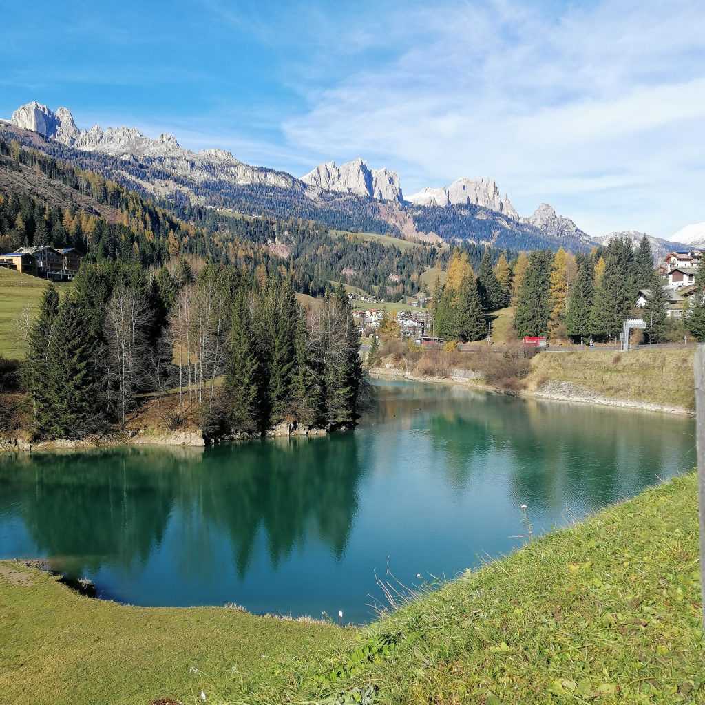 Looking across a small alpine lake to the Dolomite mountains behind